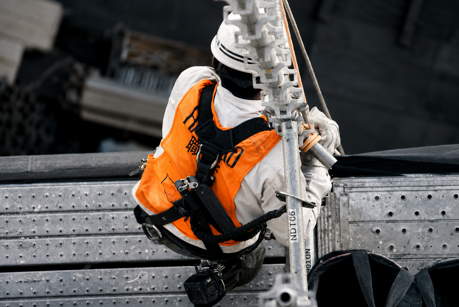 Worker secured by a fall arrest harness while working on a steel structure