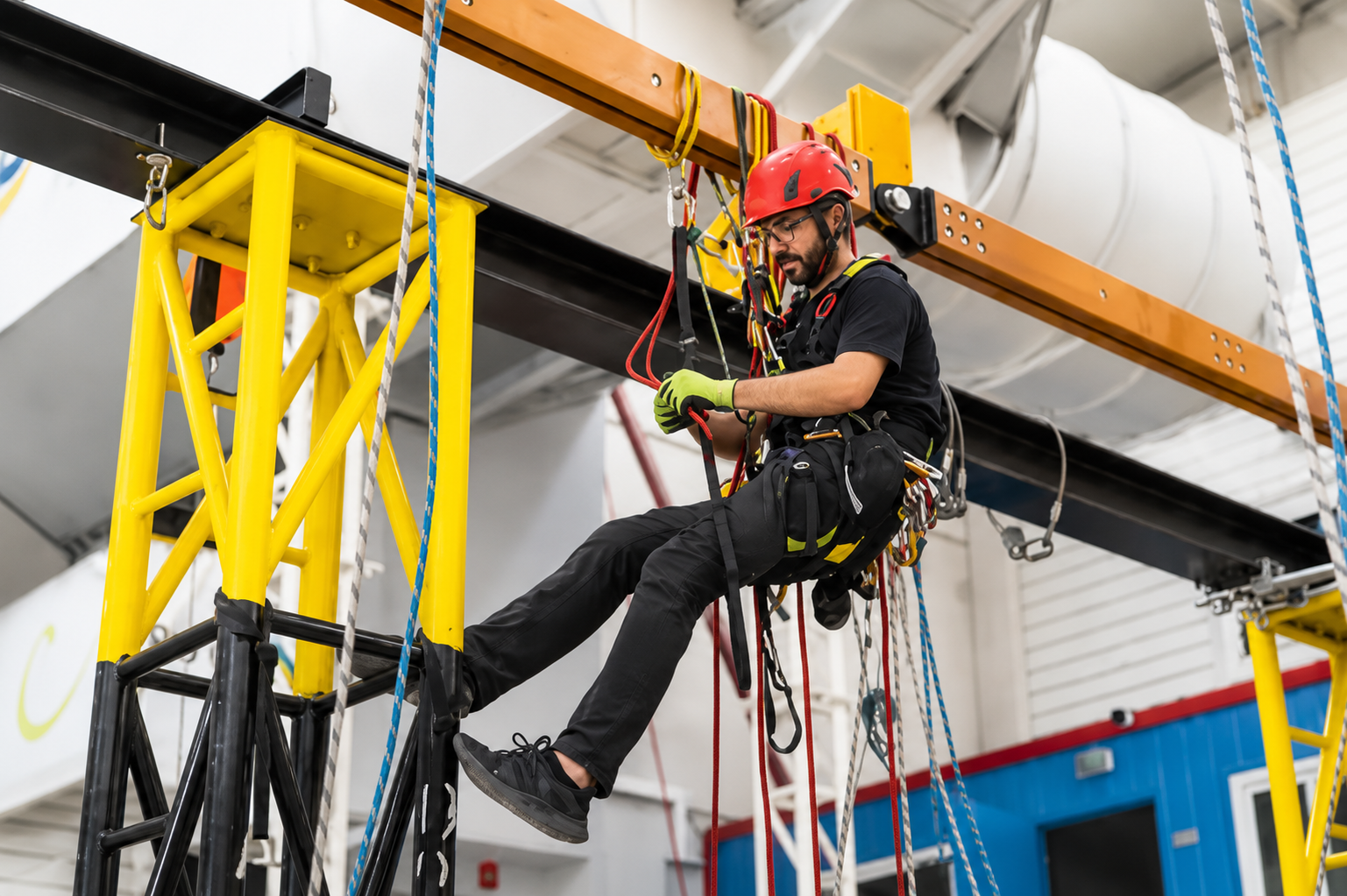 Worker tied off inside an aerial lift basket, feet firmly on the basket floor