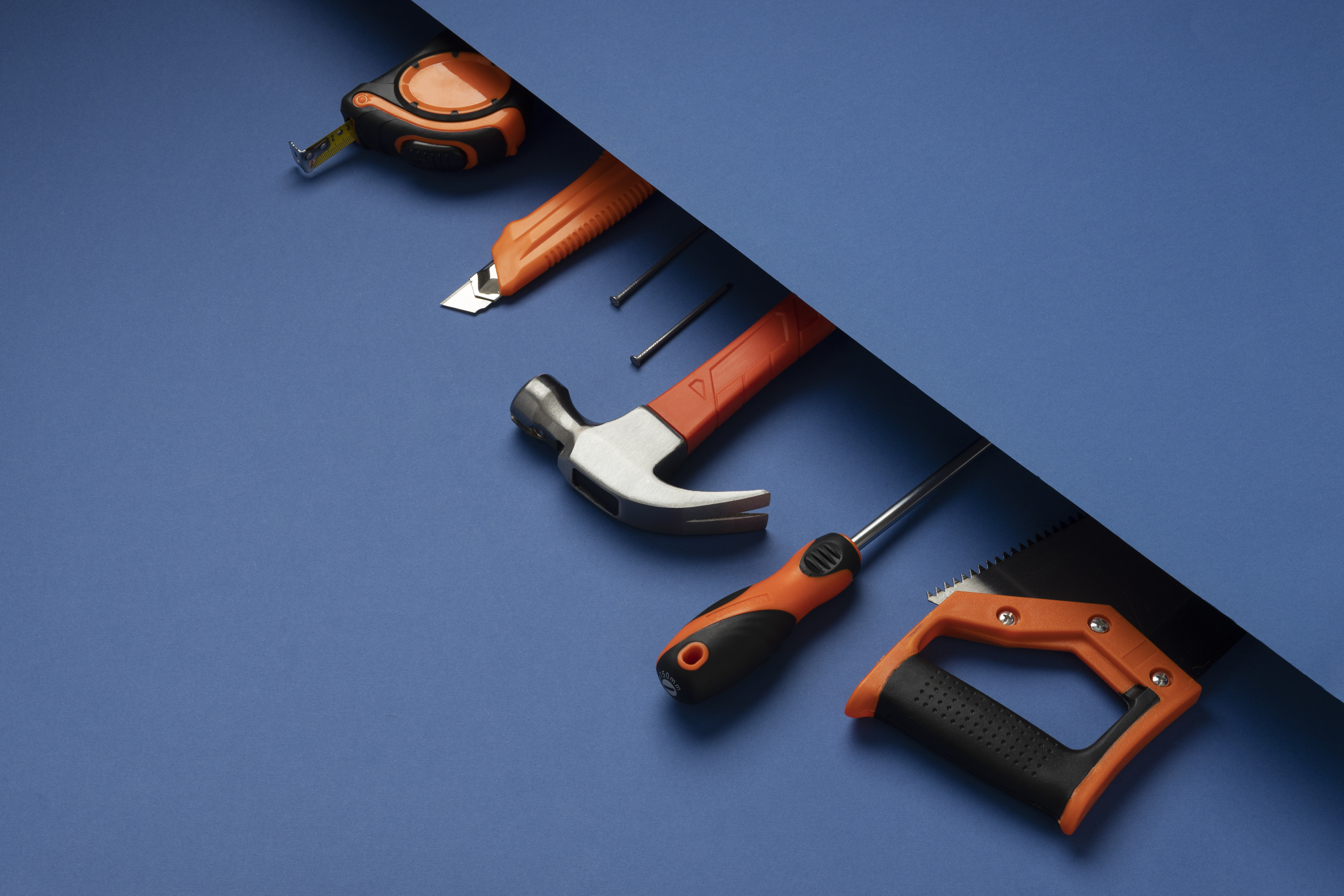 A set of professional hand tools including hammers, screwdrivers and wrenches laid on a workbench